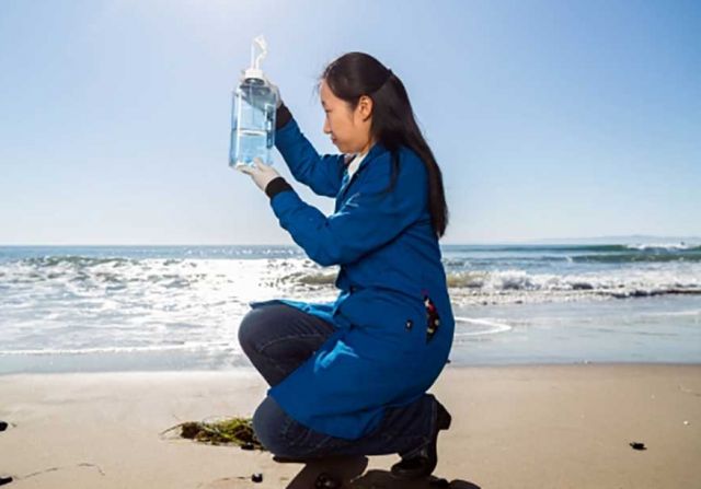 Shuting Liu holds up a sample of seawater from Campus Point. Credit: Matt Perko